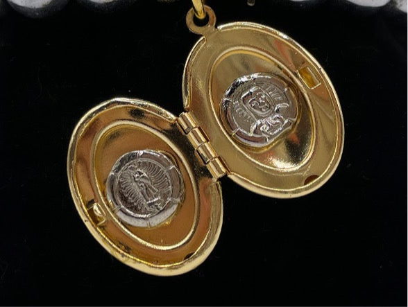 Brazalete elástico con perlas metálicas plateadas y relicario dorado en forma de óvalo, abierto y cerrado. Diseño emocional de bisutería fina.”