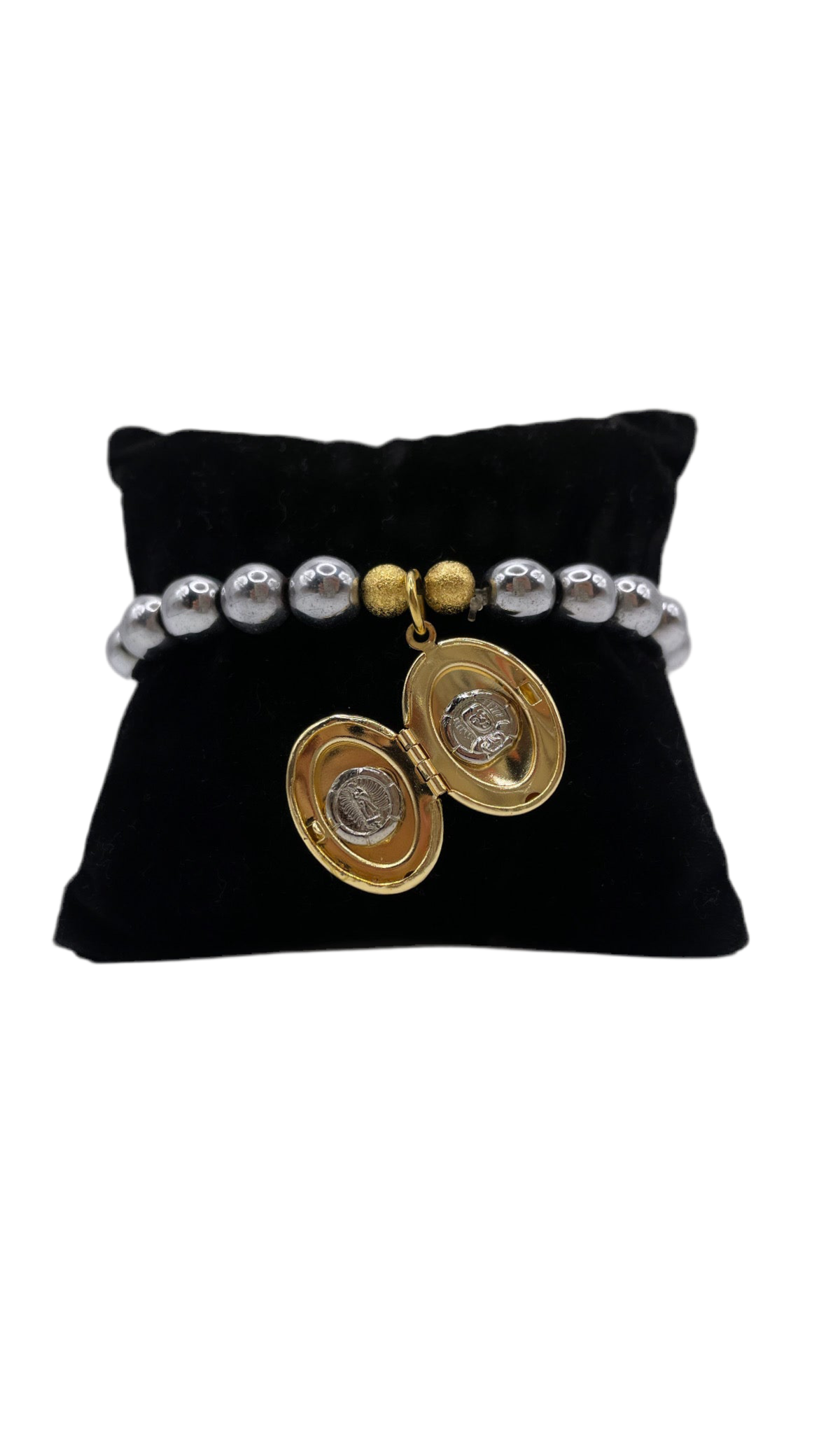 Brazalete elástico con perlas metálicas plateadas y relicario dorado en forma de óvalo, abierto y cerrado. Diseño emocional de bisutería fina.”
