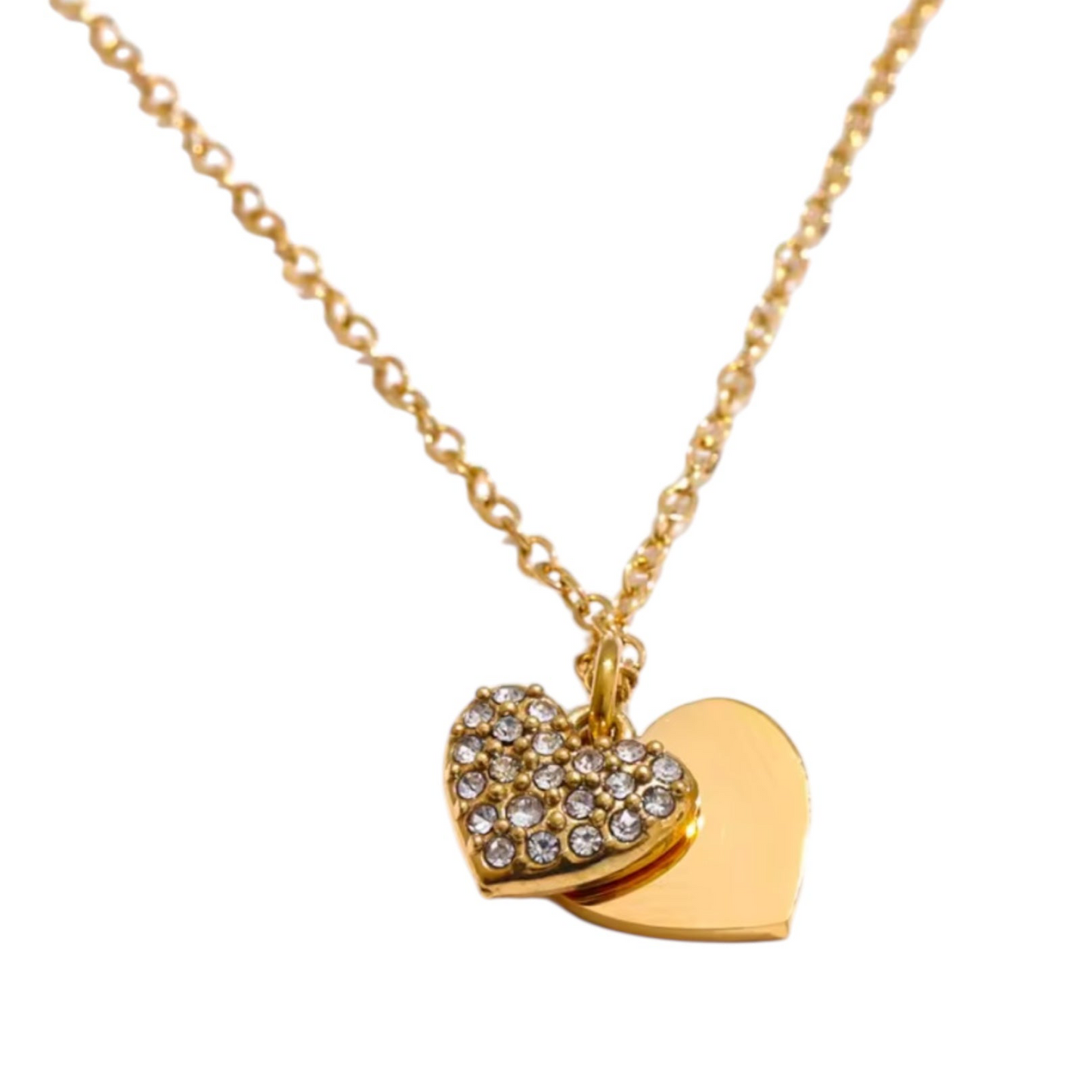 Collar de acero inoxidable con doble dije de corazón: uno liso y otro con incrustaciones de circonias brillantes. Disponible en dorado y plateado.
