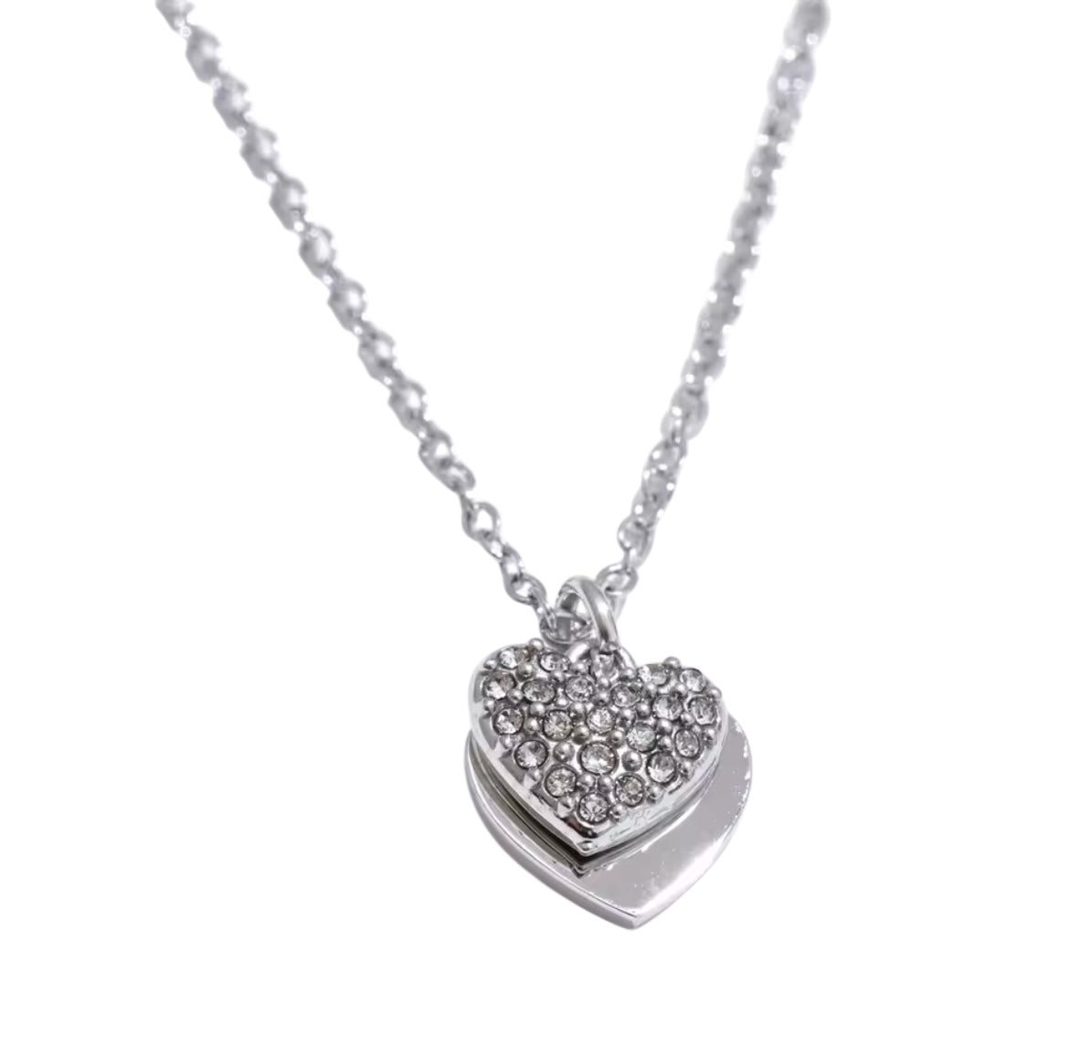 Collar de acero inoxidable con doble dije de corazón: uno liso y otro con incrustaciones de circonias brillantes. Disponible en dorado y plateado.