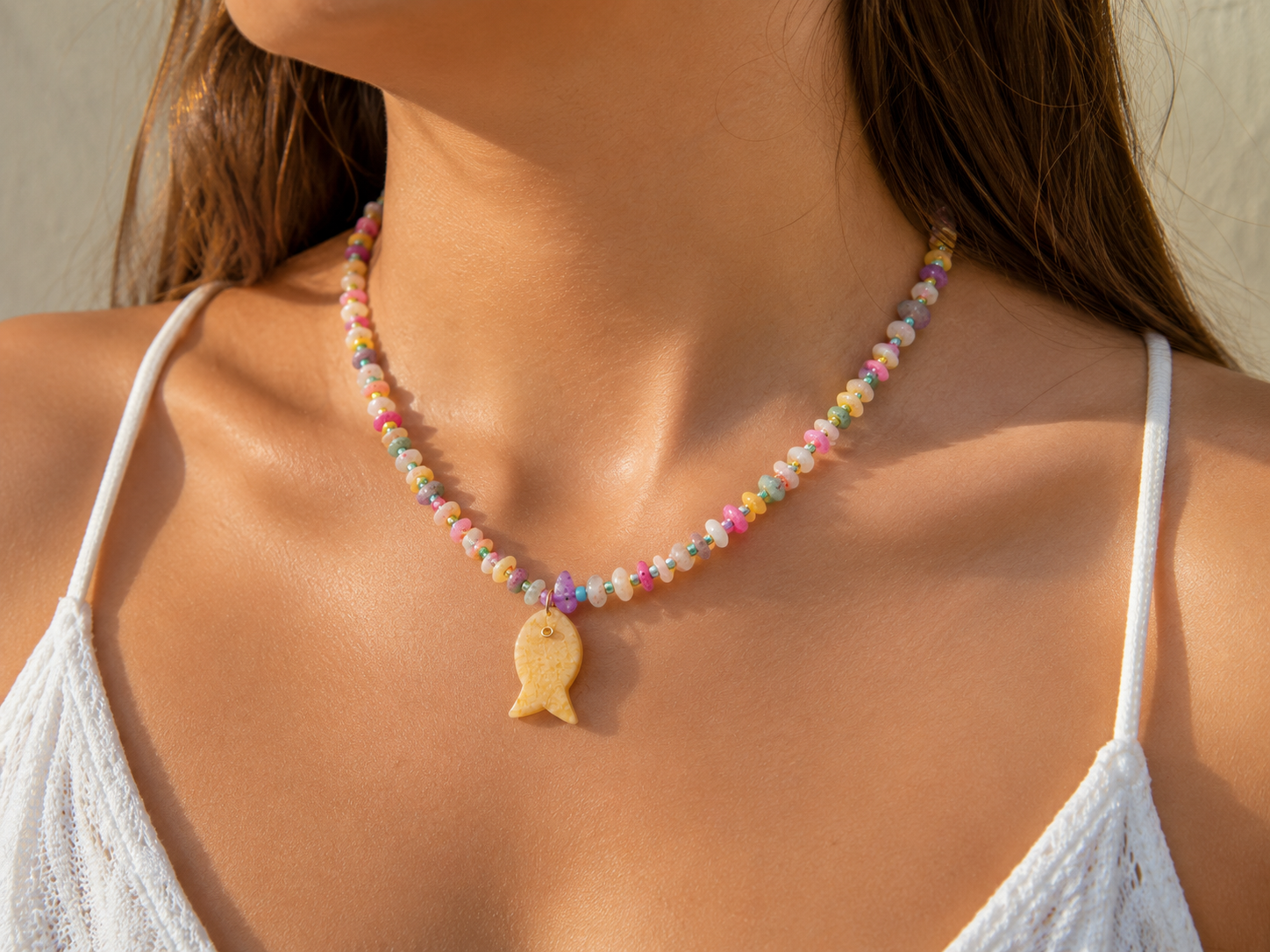 Mujer usando collar de cuarzos naturales con dije de pez de cuarzo natural.